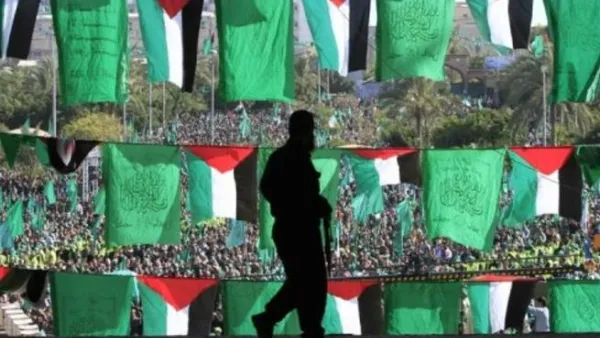 رجل يمر من امام اعلام ومتظاهرين في غزة