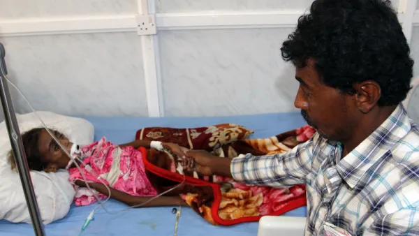 A Yemeni tends to his malnourished child as she receives treatment at a hospital in the Yemeni port city of Hodeidah. (AFP/File)
