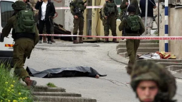 Israeli soldiers surround the body of one of the two Palestinians who were killed after attacking a soldier in Hebron, March 24, 2016. (AFP/File)