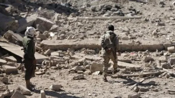 مقاتلان من الحوثيين في منطقة شهدت ضربة جوية للتحالف الذي تقوده السعودية في صنعاء 
