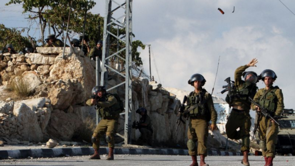 Israeli soldiers throw a flash grenade during clashes with Palestinian demonstrators in the West Bank village of Beit Fajjar, on October 31, 2015 (AFP Photo/Musa Al-Shaer)