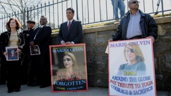 People in Oyster Bay, N.Y. hold signs of support for Marie Colvin, an American journalist killed in Syria in 2012. (AFP Photo) 