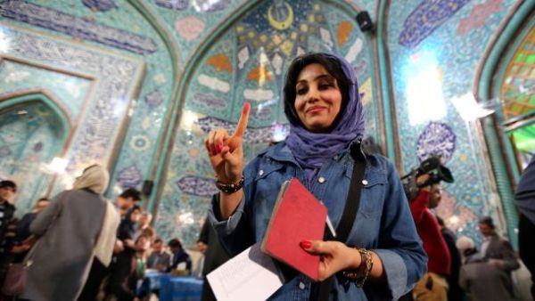 An Iranian woman voting in Iran's elections shows her inked finger after casting her ballot at a polling station in Tehran, February 26, 2016. (Photo: AFP)