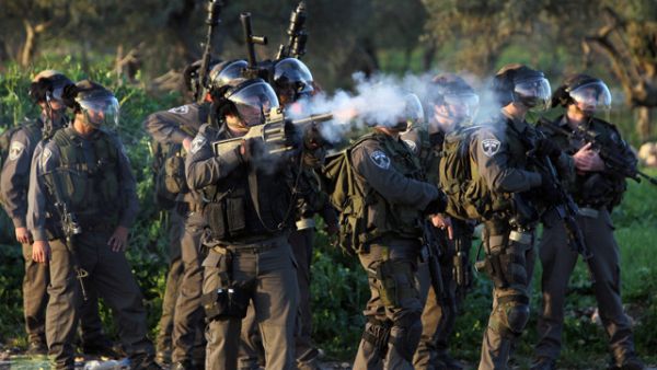 An Israeli security soldier fires a tear gas canister at Palestinian protesters. (AFP/File)