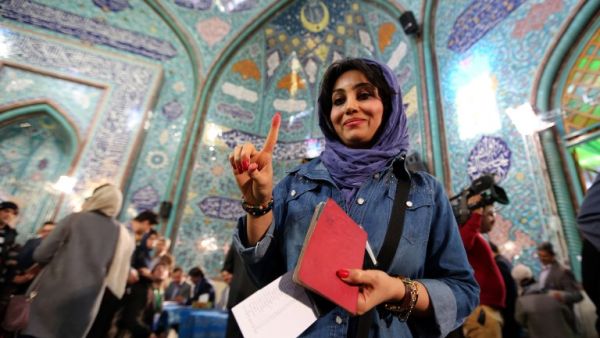 An Iranian woman shows her inked finger after casting her ballot at a polling station in Tehran on February 26, 2016. (AFP/Atta Kenare)
