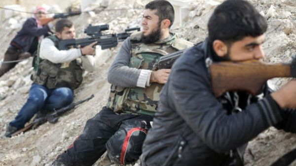 Rebels line a dirt escarpment as they look towards Syrian army positions south of the highway town of Maraat al-Numan on November 17, 2012. [Getty Images]