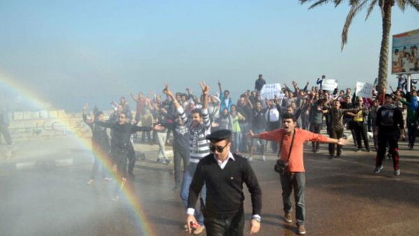 Supporters of 28-year-old blogger Khaled Said who died following police questioning before the revolution in 2010, during a demonstration outside the criminal court where the second retrial session is underway on December 2, 2013. [AFP]