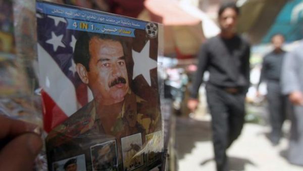 A man holds a CD with a photo of former Iraq President Saddam Hussein (AFP/Ahmad Al Rubaye)