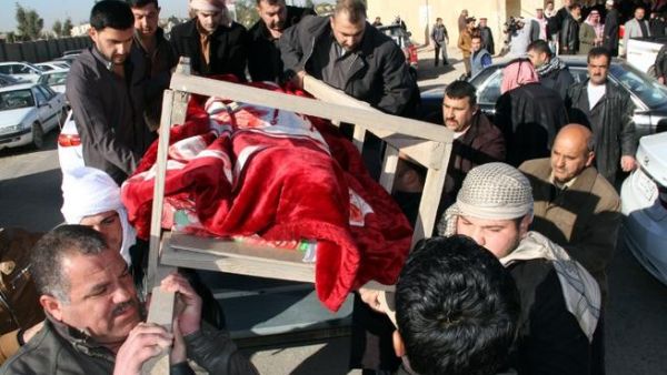 Iraqi men take part in the funeral of four of the five journalists killed in an attack on an Iraqi television station headquarters the day before, in the northern city of Tikrit, during their funeral, on December 24, 2013. [AFP]