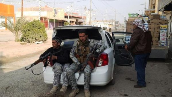 Armed tribesmen and Iraqi police sit in a car as clashes rage on in the Iraqi city of Ramadi, west of Baghdad, on January 2, 2014. [AFP]