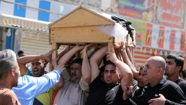 Iraqis carry the coffin of one of the victims of the attack on a Shiite mosque. [AFP]