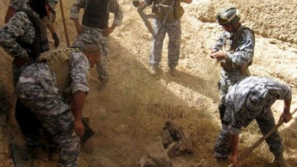 رجال امن عراقيون في موقع المقبرة الجماعية في الحلوة 