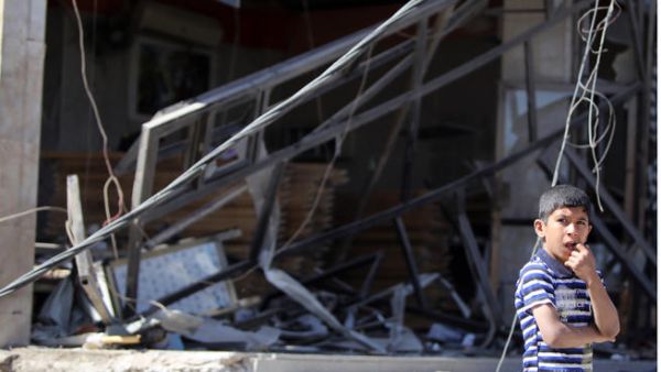 An Iraqi boy stands at the site the morning after a car bomb attack. (Image credit: AFP)