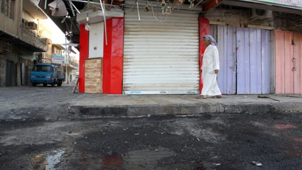 An Iraqi walks on the site of a car bomb that exploded outside a restaurant. (Image credit: AFP)