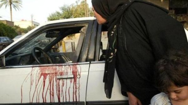 An Iraqi woman looks into a blood stained car of two women shot dead in central Baghdad earlier this month. [presstv]