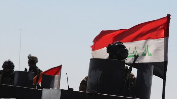 An Iraqi policeman in Ramadi sits on an armored vehicle mounted with a national flag on Feb. 12, 2016, after security forces retook the eastern outskirts of the city from Daesh. (AFP/Ahmad al-Rubaye)