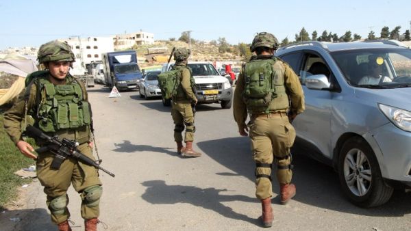 Israeli soldiers man a checkpoint at one of the entrances of the West Bank city of Hebron, on November 23, 2015. (AFP/Hazem Bader)