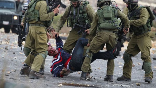 Israely soldiers detain a wounded Palestinian stone thrower during clashes in Beit El, on the 17 October 2015. (AFP /Abbas Momani)