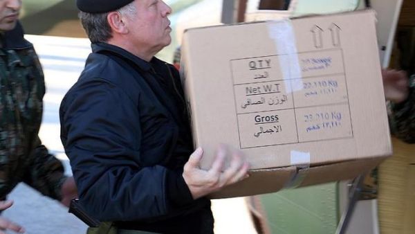 King Abdullah of Jordan loading a box containing ready meals onto a helicopter during his visit to the Northern Command in Ajloun, as he follows up on the national effort to deliver services and goods to citizens caught in the snow storms through out the kingdom. [AFP]