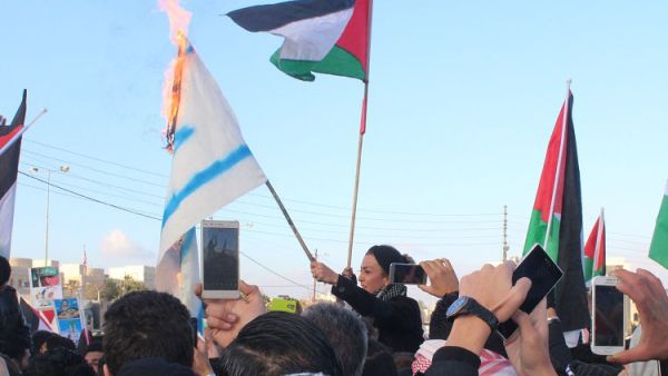 محتجون يحرقون علم "اسرائيل" خلال الاعتصام أمام السفارة الأميركية في عمان