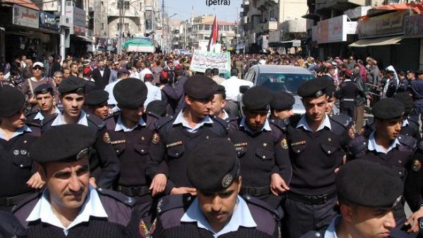 رجال أمن يحمون المتظاهرين من البلطجية