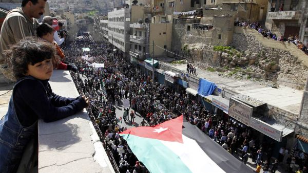 Thousands of Jordanians hold a giant national flag during a demonstration on March 4, 2011, in Amman to demand "regime reforms," a day after Prime Minister Maaruf Bakhit rejected calls for a constitutional monarchy. (AFP/Khalil Mazraawi)