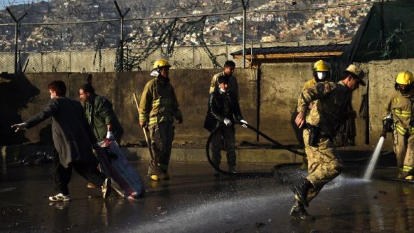 Afghan firefighter wash the site after a Taliban suicide attacker detonated himself at the entrance to a police base in Kabul on February 1, 2016. (AFP/Wakil Kohsar)