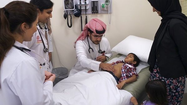 الطالب ناصر بن مرزوق خلال إجراء فحص لأحد الأطفال المشاركين في فعالية نجوم كورنيل.