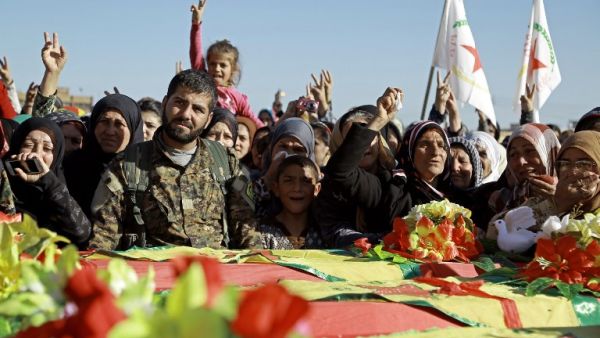 Syrian Kurds mourn next to coffins as they attend the funeral procession of four Kurdish fighters in the northeastern Syrian city of Qamishli on February 18, 2016. (AFP/Delil Souleiman)