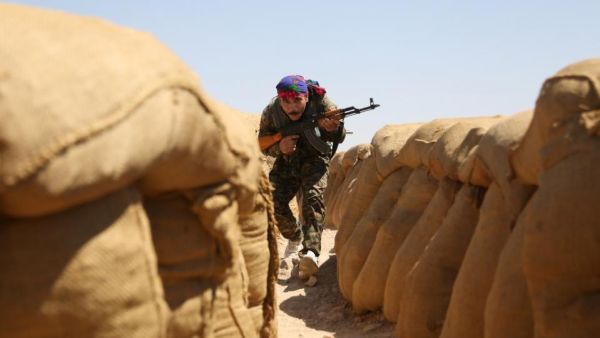 A fighter from the Kurdish People Protection Unit (YPG) walks between sandbags on the front line in the northeastern Syrian city of Hasakeh on September 4, 2015 (AFP/Delil Souleiman)