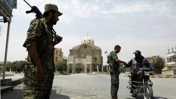 Members of the Kurdish police patrol in the neighborhood of Al-Masaken in the northeastern Syrian city of Hasaka during ongoing fighting with regime forces on August 22, 2016. (AFP/Delil Souleiman)