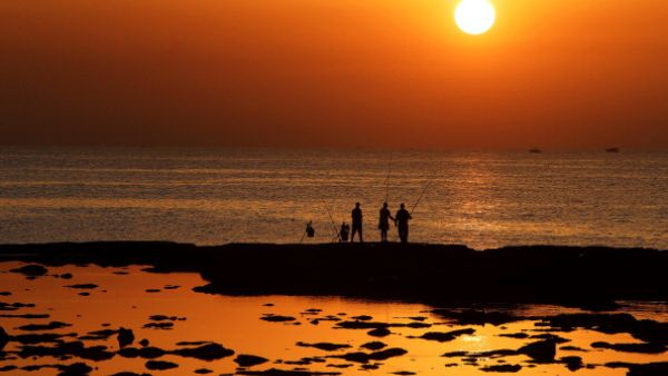 A breathtakingly beautiful land of contradictions - Lebanese men enjoy a peaceful moment fishing during sunset outside the northern city of Tripoli, where armed clashes have broken out between Sunni and Shia residents. (AFP/Joseph Eid)