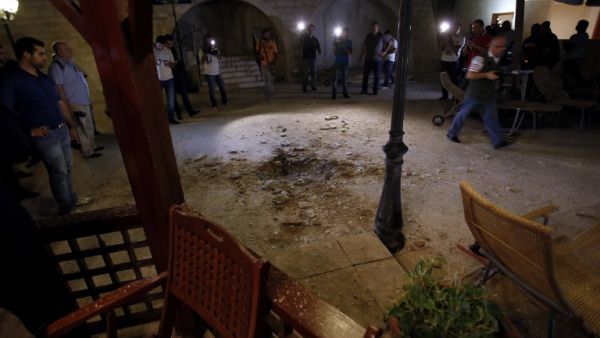 LEBANON, BAABDA : Journalists inspect the damage at a private residence where one of two rockets fired from an unknown location exploded in the early hours of August 2, 2013, just metres from an entrance to the presidential palace in Baabda. AFP PHOTO / ANWAR AMRO