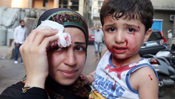 A boy and his mother are seen at the site of a car bomb between the Bir el-Abed and Roueiss neighborhoods, in the southern suburb of Beirut (AFP/STR)