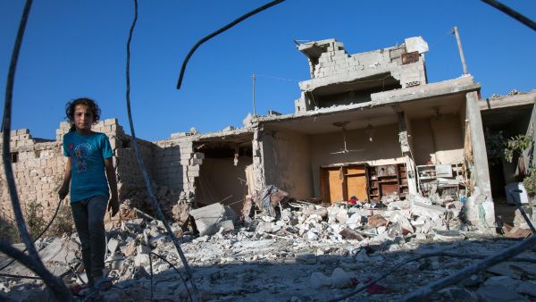 A Syrian girl walks next to the debris of her house, after it was targeted by a missile, in the northwestern Syrian province of Idlib on July 18, 2013. (Source: AFP/DANIEL LEAL-OLIVAS)