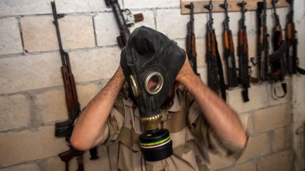 A Syrian rebel tries on a gas mask seized from a Syrian army factory in the northwestern province of Idlib (AFP/DANIEL LEAL-OLIVAS