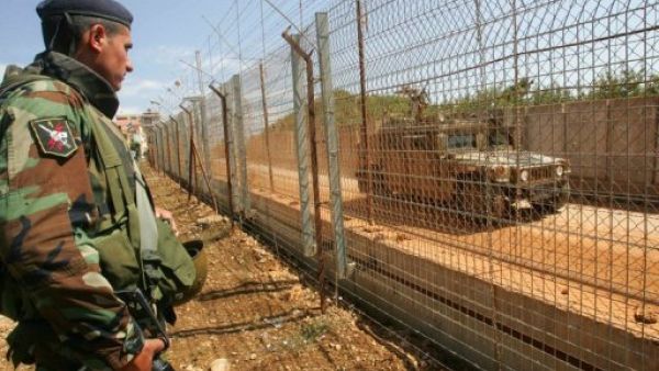 جندي لبناني على الحدود اللبنانية الاسرائيلية جنوب لبنان ينظر الى دورية للجيش الاسرائيلي من في بلدة كفركلا