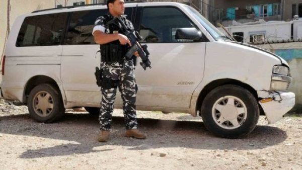 عنصر من قوى الامن اللبنانية يقف الى جانب سيارة فان يعتقد انها استخدمت في خطف الاستونيين، في البقاع