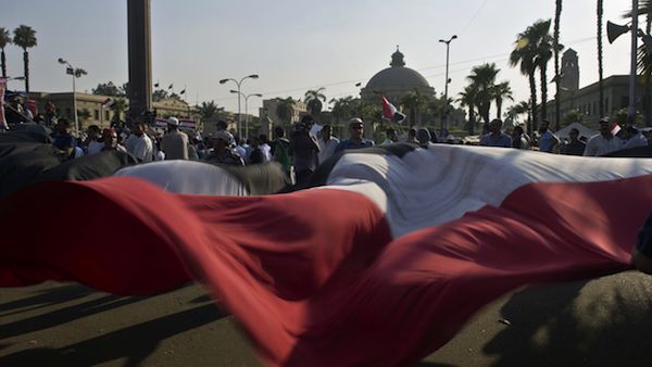 Egyptian supporters of President Mohamed Morsi wave a large national flag during a rally outside Cairo University (Source: AFP/KHALED DESOUKI)