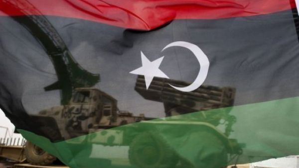 A Libyan flag flown in front of a military vehicle. (AFP/File)