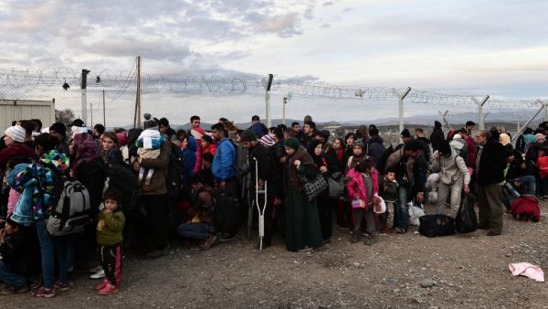Syrian and Iraqi refugees wait to cross the border into Macedonia near the village of Idomeni on February 27, 2016. (AFP/Louisa Gouliamaki)