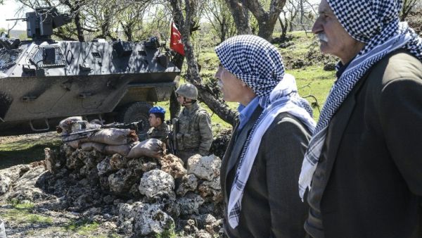 Kurdish men wait in front of Turkish military barricade as they try to enter Cizre for Newroz celebration in Mardin, on March 22, 2016. (AFP/Ilyas Akengin)