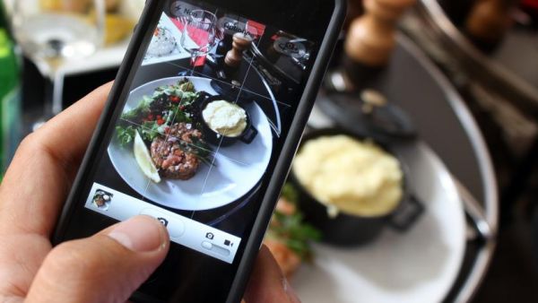 A man photographs his meal with a cell phone. Photograph by Ana Arevalo. AFP