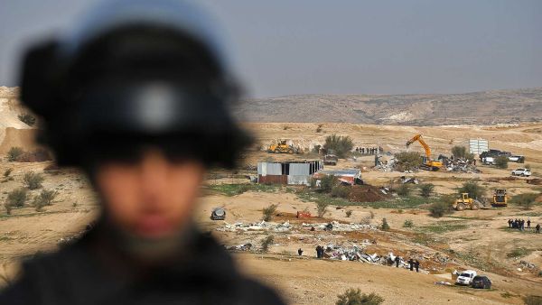 Israeli policemen stand guard as bulldozers demolish homes in the Bedouin village of Um al-Hiran (AFP/File Photo)	