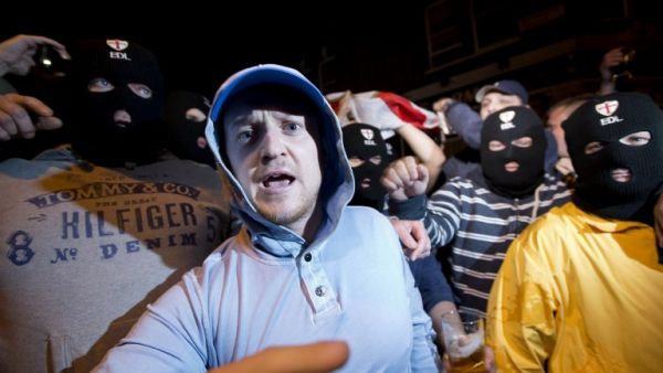 Members of the English Defence League (EDL) wear balaclavas as they gather outside a pub in Woolwich in London on May 22, 2013 after a man believed to be a serving British soldier was brutally murdered nearby in what Prime Minister David Cameron said appeared to be a terrorist attack (Justin Tallis / AFP)