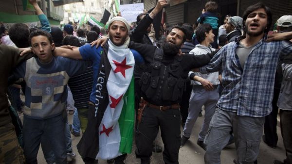 Syrian men dance and chant revolutionary slogans during the commemoration of the second anniversary of the Syrian conflict, in Bustan al-Qasr district of Aleppo. (AFP PHOTO/JM LOPEZ)