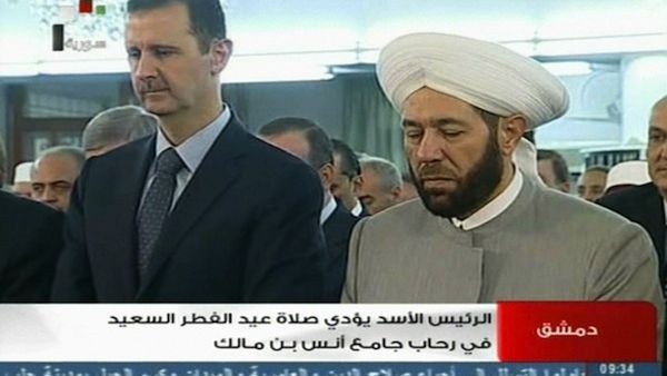 Not dead yet:  Syrian President Bashar al-Assad (L) and Syrian Grand Mufti Ahmed Hassun attend the morning prayer of Eid al-Fitr in Damascus on Thursday shortly after the FSA claimed to have attacked his convoy. (AFP)