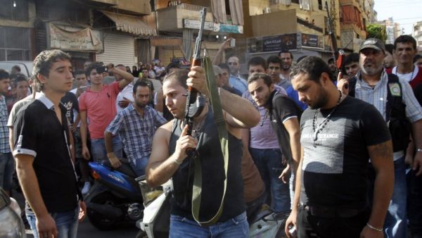 A Lebanese gunman is seen during the funeral procession of Hamad al-Moqdad, one of the Lebanese victims of a car bomb attack that killed dozens in a Beirut stronghold of Shiite group Hezbollah, which backs Syria's embattled president, in the capital on August 16, 2013. (AFP)
