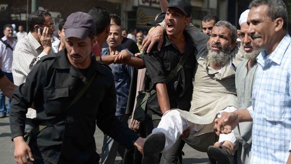 Egyptian policemen carry an Islamist man outside Cairo's Al-Fath mosque where Islamist supporters of ousted president Mohamed Morsi held up on August 17, 2013. (AFP)