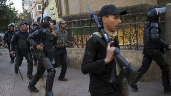 Egyptian riot policemen run after Muslim brotherhood members following a demonstration in Cairo's eastern Nasr City district on December 27, 2013. [AFP]